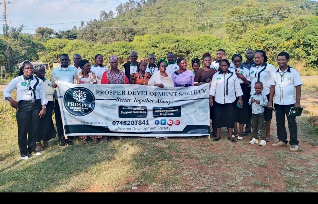 Prosper community members gathered together with the Society banner